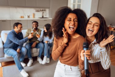 Bir grup farklı genç arkadaş kutlama yapıyor, şarkı söylüyor ve modern konforlu bir dairede parti aktivitelerine katılıyor, birlikte rahatlatıcı ve keyifli hafta sonlarının tadını çıkarıyorlar. Seçici odak