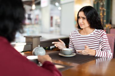 Kızgın genç Hintli kadın jest yapıyor ve yüzünü buruşturuyor. Kahve dükkanında romantik bir randevudayken erkek arkadaşıyla kavga ediyor. Doğulu çift ilişkilerde zorluklar yaşıyor, ayrılık yaşıyor
