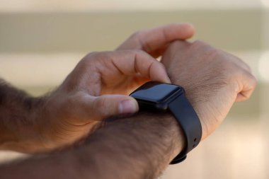 Spor yaparken, erkek ellerinin spor yaparken akıllı spor takip cihazı kullanırken yakın plan görüntüsü. Günlük egzersiz araçları, sağlık ve sağlık için kardiyo eğitimi. Kırpılmış