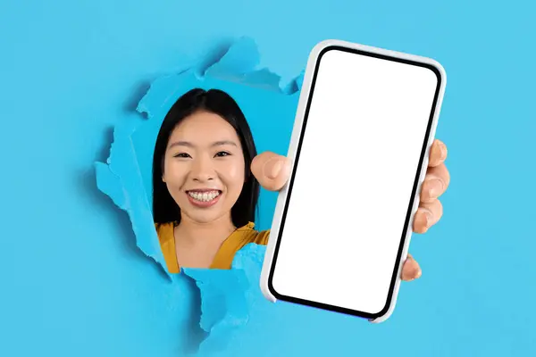 Veselá Mladá Asiatka Usmívá Potrhaným Modrým Papírem Představuje Telefon Prázdnou — Stock fotografie