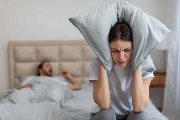 Exasperated Woman Sits Bed Pillow Clutched Her Ears Futile Attempt — Stock Photo, Image