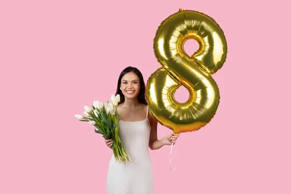 白いチューリップと黄金の気球でウォームズデーを祝う笑顔の女性は 陽気なピンクの背景に対して 3月8日を象徴する数字8として形作られました — ストック写真