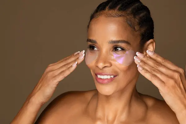 Joyful Black Woman Braided Hair Applying Hydrating Eye Patches Showcasing — Stock Photo, Image