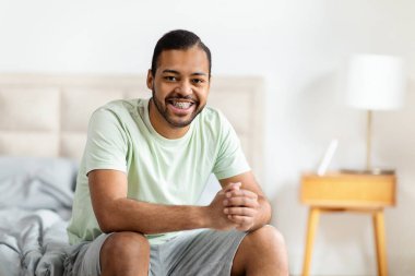 İyi uykular. Pozitif yakışıklı, sakallı, pijama giyen Amerikalı adam uyandıktan sonra yatağa oturuyor, kameraya gülümsüyor, yatak odasının içinde rahat bir oda, fotokopi çekiyor.