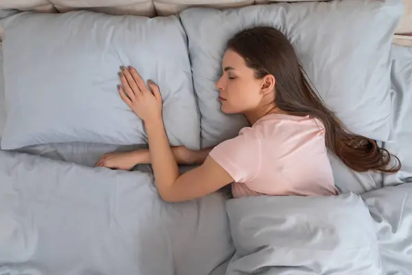 Young Woman Lies Restful Slumber Clutching Pillow Her Relaxed Pose — Stock Photo, Image