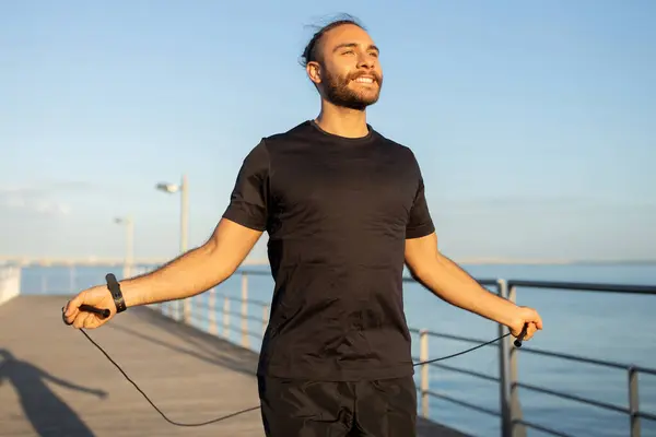夏日有氧运动锻炼 积极的运动员在海滨的码头上跳绳 在室外锻炼 促进健康的运动动机和健康的运动生活方式 带着微笑把目光投向一边 — 图库照片