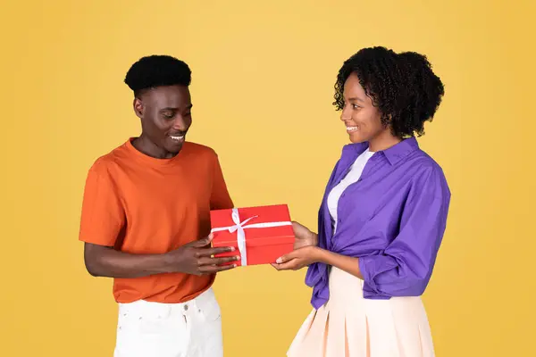 Een Vrolijke Vrolijke Zwarte Jongeman Een Oranje Shirt Presenteert Een — Stockfoto
