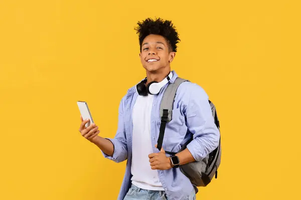 Nadšený Muž Student Batohem Sluchátka Kolem Krku Držící Smartphone Ztělesňující — Stock fotografie
