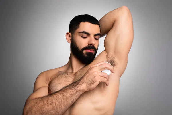 Middle Eastern Man Applying Deodorant Antiperspirant Armpit Standing Grey Background — Stock Photo, Image