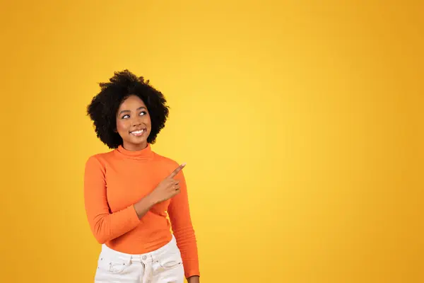 Sonriente Joven Afroamericana Mujer Señala Algo Fuera Cámara Mostrando Interés —  Fotos de Stock