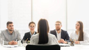 İK yöneticileri kadın adaylarla iş görüşmesi yapıyor, pencerenin önünde oturuyorlar.