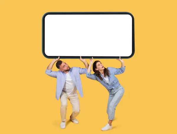 Enthusiastic Couple Playfully Lifting Oversized Smartphone Blank Screen Perfect Advertising — Stock Photo, Image