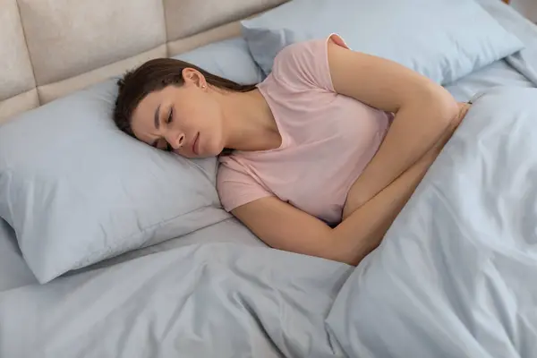 Concerned Young Woman Experiencing Abdominal Pain Curled Her Side Bed — Stock Photo, Image