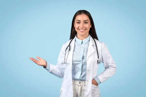 Lächelnde Ärztin Die Mit Einer Hand Etwas Unsichtbares Präsentiert Stethoskop — Stockfoto
