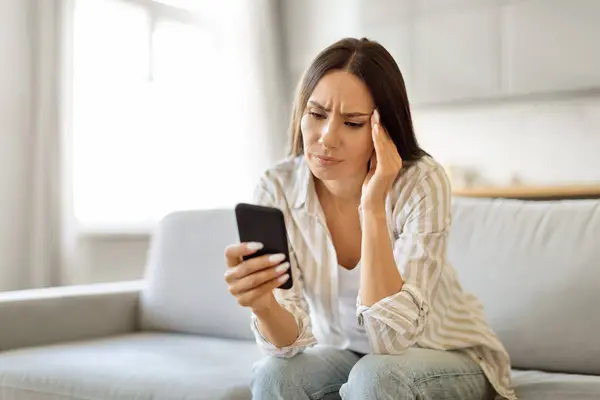 Jovem Preocupada Lendo Mensagem Texto Seu Telefone Celular Cabeça Tocando — Fotografia de Stock