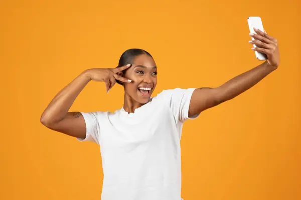 Akıllı Telefonuyla Işareti Yapan Mutlu Afro Amerikalı Kadın Stüdyo Ortamında — Stok fotoğraf