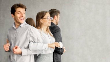 Birliktelik. Takım kurma kursundaki iş ekibi sırt sırta durarak, hasat...