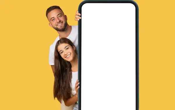 Sevinçli Avrupalı Genç Bir Çift Büyük Bir Akıllı Telefonun Arkasından — Stok fotoğraf
