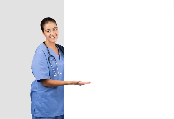 Convidando Enfermeira Europeia Esfoliação Azul Apresentando Gesto Mão Aberta Lado — Fotografia de Stock