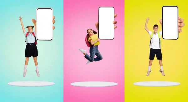 Tres Escolares Uniforme Saltando Alegremente Con Teléfono Inteligente Blanco Mano — Foto de Stock