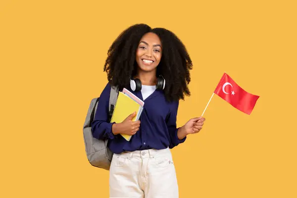 Veselá Mladá Černoška Kudrnatými Vlasy Sluchátky Zápisníky Tureckou Vlajkou Zářivým — Stock fotografie