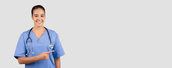 Vriendelijke Blanke Duizendjarige Medische Professional Blauwe Scrubs Wijzen Naar Zijkant — Stockfoto