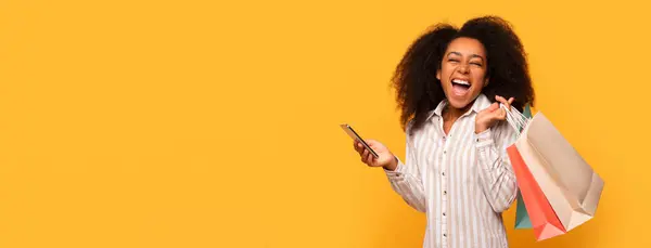Encantada Jovem Mulher Negra Segurando Sacos Compras Usando Smartphone Celebrando — Fotografia de Stock