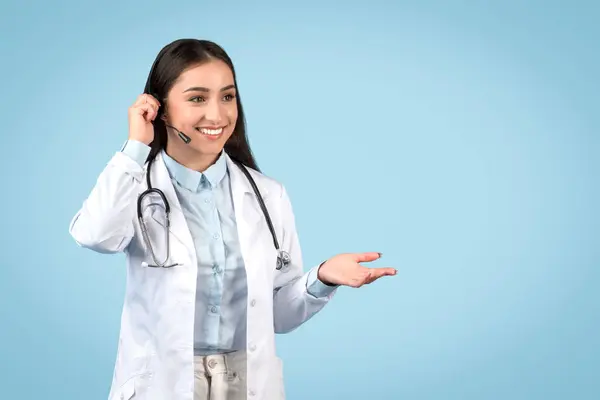 Leende Ung Kvinnlig Läkare Bär Headset Gör Välkomnande Gest Klädd — Stockfoto