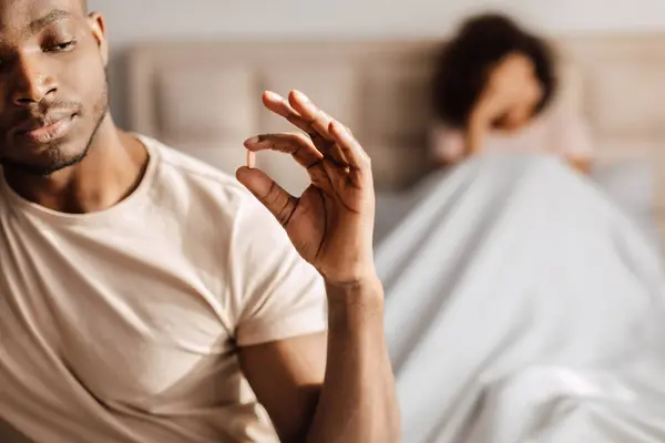 Young Black Man Taking Potency Pill Sitting Bed Wife Bedroom — Stock Photo, Image