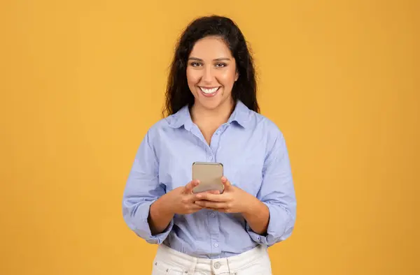 Mavi Tişörtlü Mutlu Genç Bir Kadın Elinde Akıllı Bir Telefonla — Stok fotoğraf
