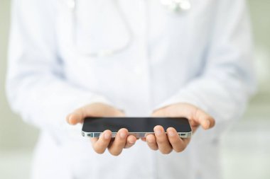 Kadın doktor ellerinde cep telefonu, siyah boş ekran kopyalama alanı, sağlık hizmetlerindeki modern teknolojiler için pankart, mobil tıbbi uygulama, tele sağlık konsepti.