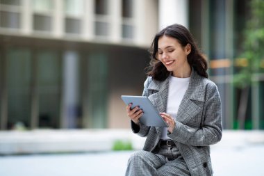 Genç iş kadını şehir dışında otururken dijital tablet ve web sörfü uygulaması kullanıyor, öğreniyor ya da çevrimiçi çalışıyor. Teknoloji ve internet teklifleri. Metin için boş boşluk