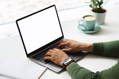 Kafe 'de çalışan, pencerenin yanındaki masada oturan, beyaz ekran fotokopi alanı olan bilgisayar laptopu kullanan, kahve içen siyahi girişimci. Uzak iş