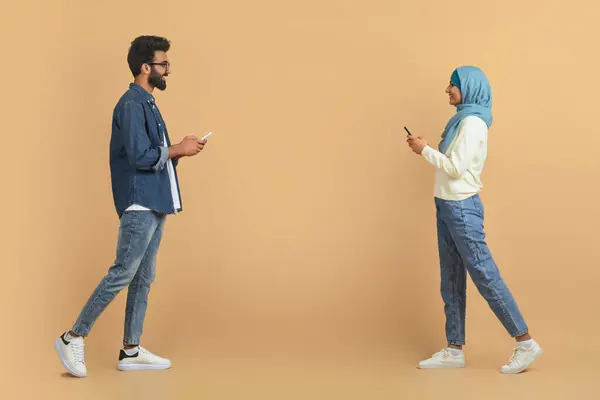 Muzułmańska Para Pochłonięta Telefonami Komórkowymi Przechodząc Obok Siebie Młody Arabski — Zdjęcie stockowe