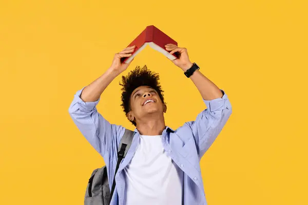 Hravý Mladý Černošky Student Vytváří Střechu Nad Hlavou Červenou Knihou — Stock fotografie