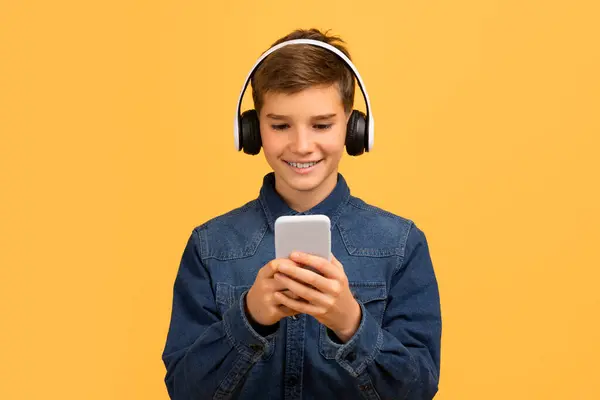 Smiling Teen Boy Wearing Wireless Headphones Using Modern Smartphone Happy — Stok Foto