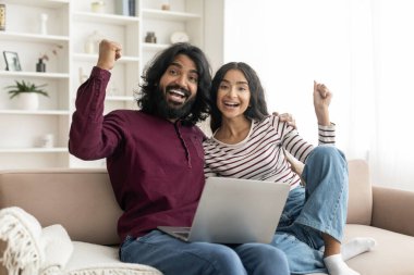 Hediye, piyango, nakit para. Duygusal olarak mutlu olan Hintli çift evlerinde oturmuş, el kol hareketi yapıyor, övgüler yağdırıyor, başarıyı kutluyor, internette kumar oynuyor, dizüstü bilgisayar kullanıyor, yer kopyalıyor.