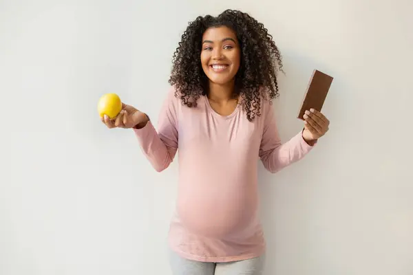 Pregnancy Cravings Black Smiling Pregnant Woman Holding Apple Chocolate Bar — Stock Photo, Image