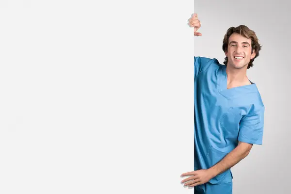 Enfermeira Alegre Azul Esfrega Inclinado Sobre Placa Branca Branco Oferecendo — Fotografia de Stock