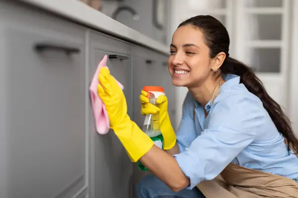 Content Woman Blue Shirt Yellow Gloves Carefully Wipes Kitchen Cabinets — Stock Photo, Image