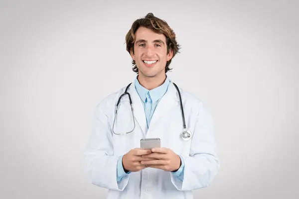 Счастливый Врач Мужчина Белом Халате Стетоскопом Смартфоне Представляющий Использование Мобильных — стоковое фото