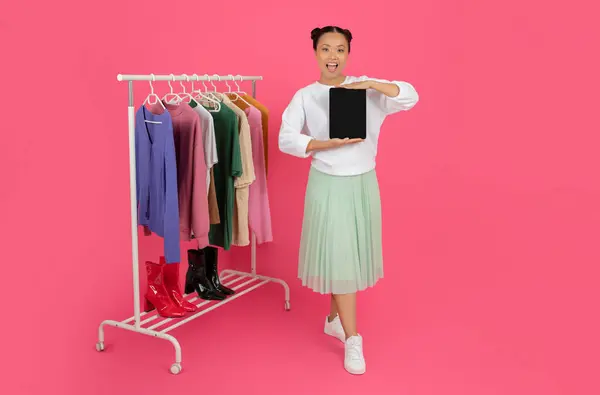 Ασιάτισσα Γυναίκα Στέκεται Κοντά Rack Ρούχα Και Δείχνει Κενή Ψηφιακή — Φωτογραφία Αρχείου