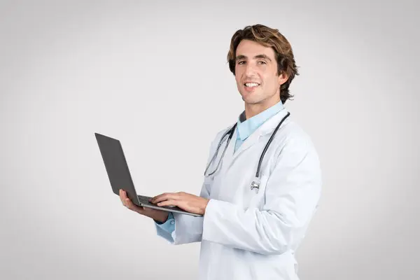 Усміхнений Чоловік Лікар Тримає Відкритий Ноутбук Представляючи Інтеграцію Технологій Сучасну — стокове фото