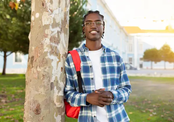 Estudante Negro Confiante Cara Inclinado Contra Árvore Posando Com Mochila — Fotografia de Stock