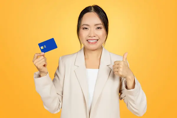 Milenar Sorridente Mulher Negócios Japonesa Terno Mostrar Cartão Crédito Polegar — Fotografia de Stock