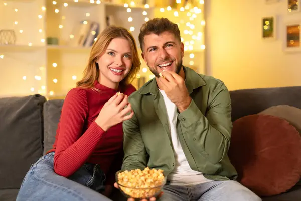 Těší Pár Sdílení Smíchu Při Jídle Popcorn Útulné Pohovce Pozadím — Stock fotografie