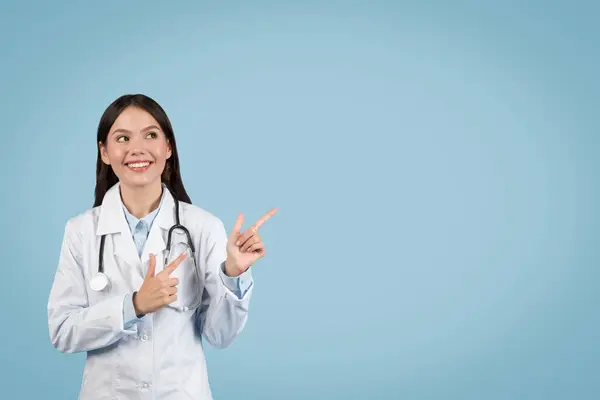 Весела Жінка Лікар Спрямовує Вгору Вільний Простір Дивлячись Щось Цікаве — стокове фото