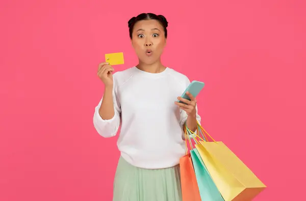 Mulher Asiática Chocada Segurando Smartphone Cartão Crédito Sacos Compras Enquanto — Fotografia de Stock