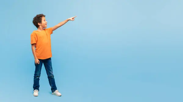 Fröhlicher Junge Mit Lockigem Haar Orangefarbenem Hemd Und Jeans Mit — Stockfoto