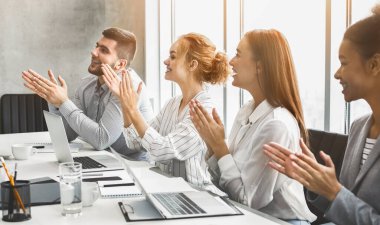 Mutlu motivasyonlu iş ekibi konferanstan hoparlöre alkışlıyor